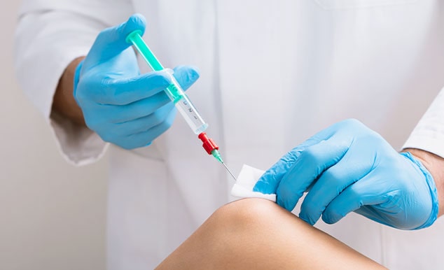 Doctor performing regenerative knee treatment